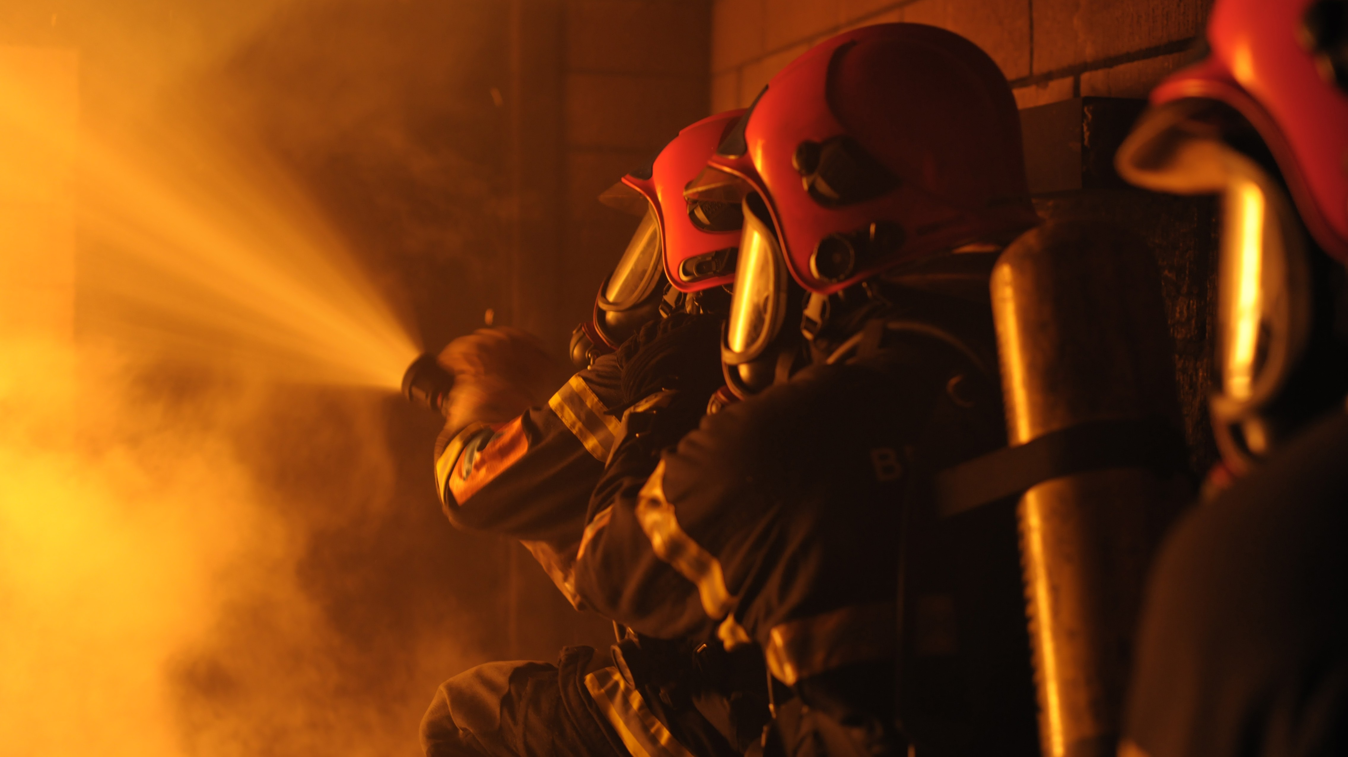 En brandmand med ild i baggrunden.