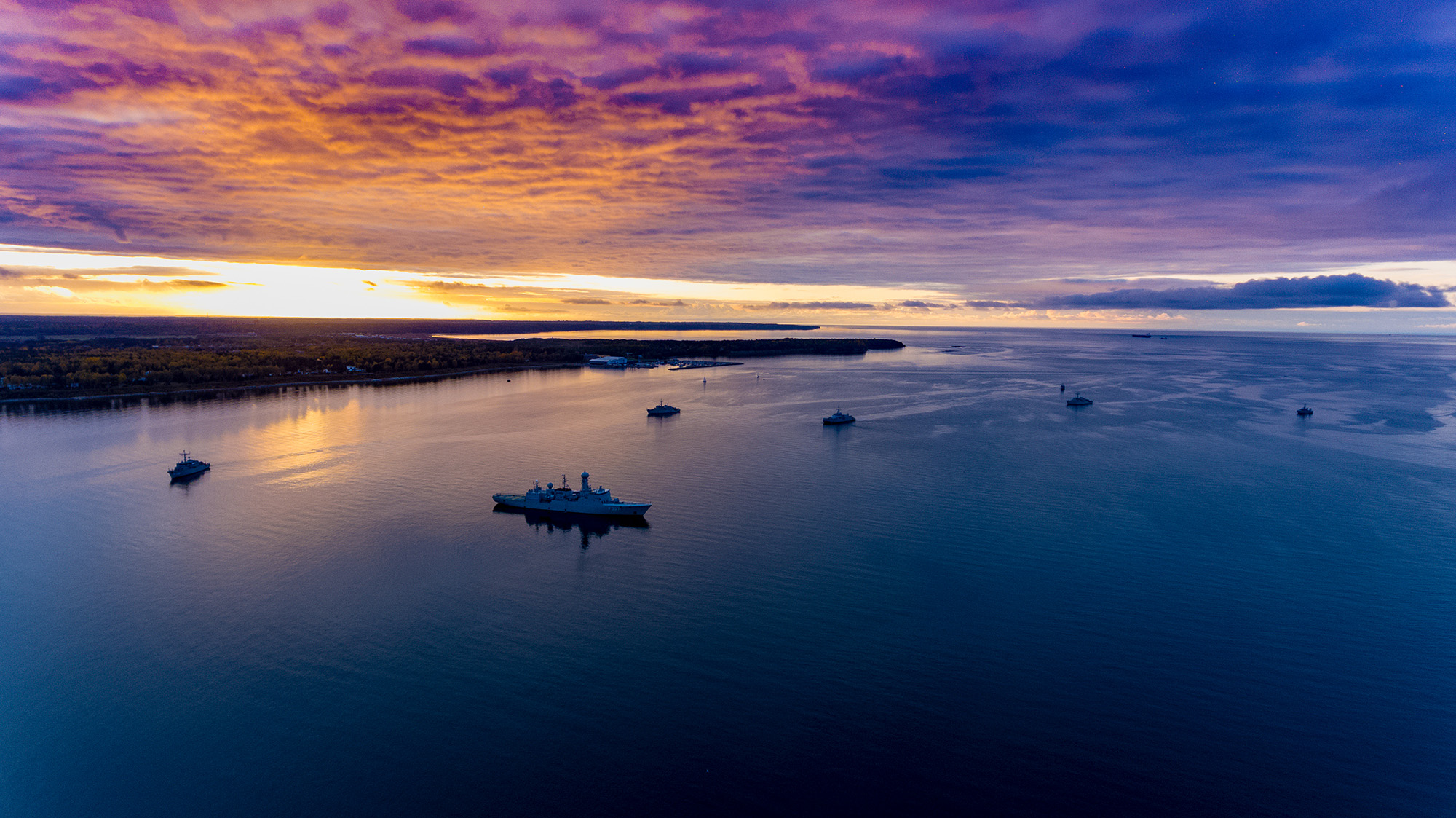 Et skib på et stille hav om natten med solnedgang.