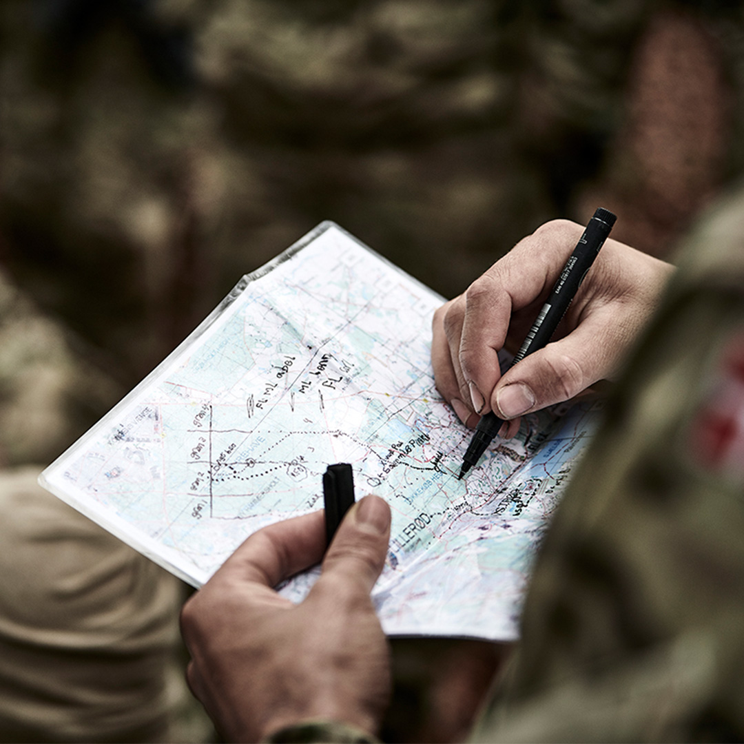 Billede af to hænder der holder et kort der bliver skrevet på