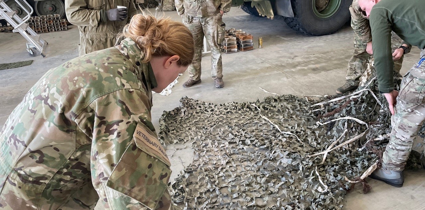 Afdelingsdyrlæge Lena i gang med at folde et net ud på gulvet