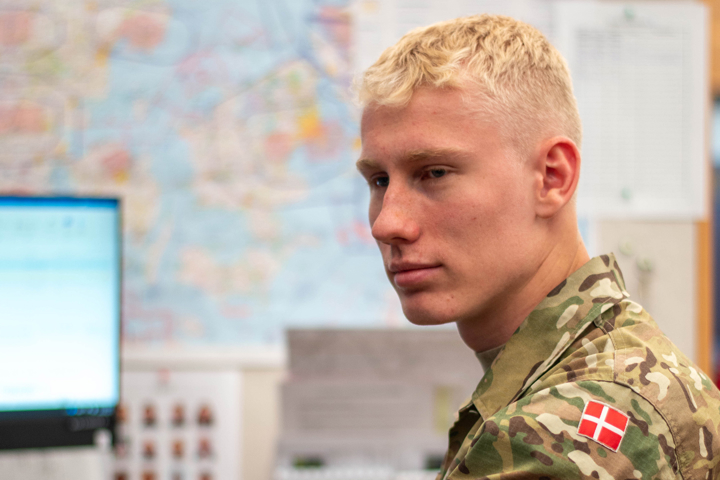 flyveinformationsoperatør sidder foran skærme, kigger til siden