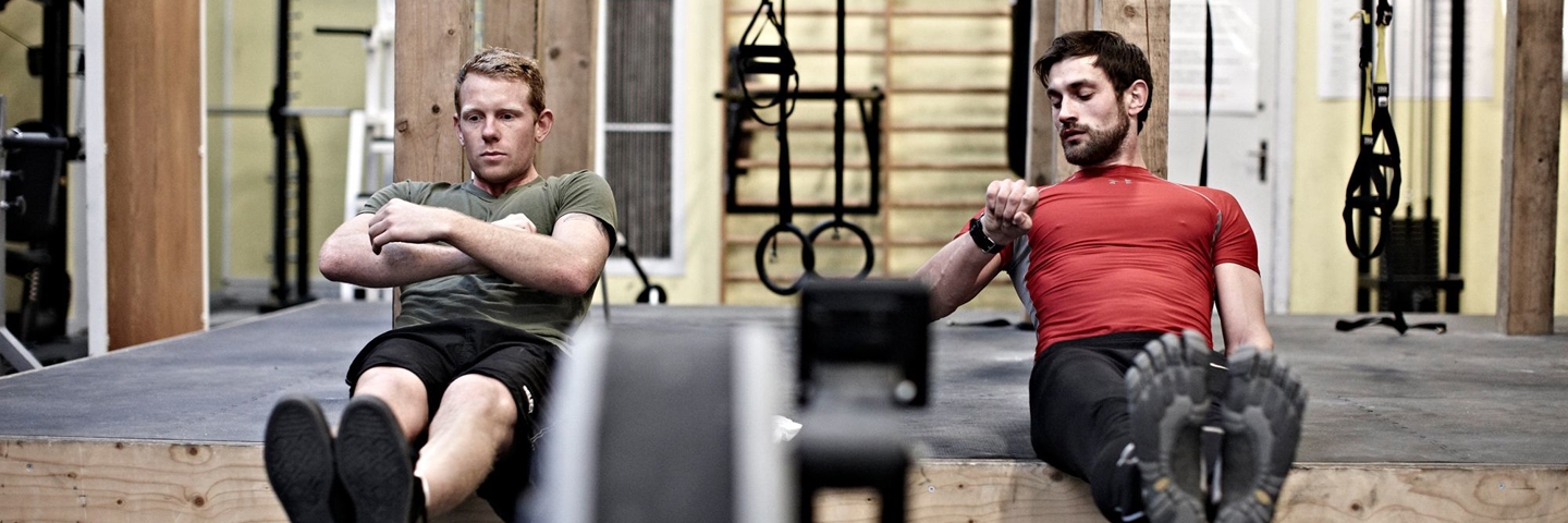 to soldater i et træningslokale laver fysiske øvelser