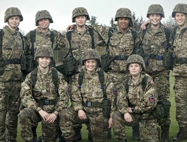 Gruppebillede af soldater i fuld feltmæssig uniform der kigge mod kammeraet