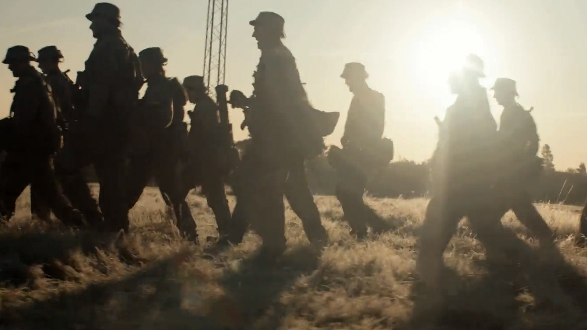 Silhuetter af soldater med solen i baggrunden