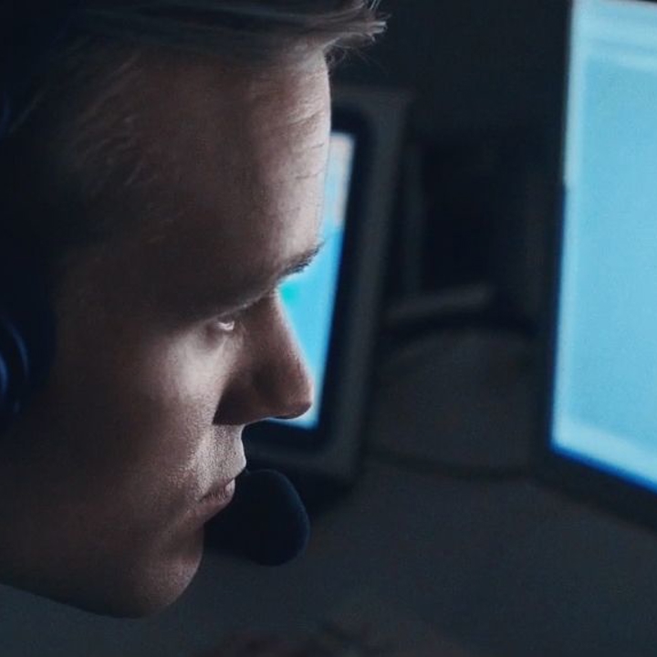 Officer sidder i mørkt rum og kigger på en oplyst skærm