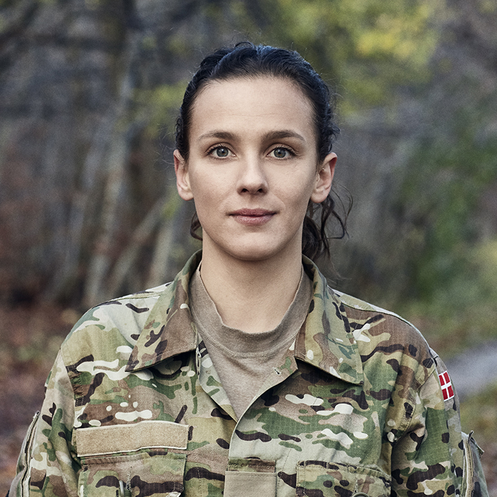 Marie kigger ud mod kameraet i sin uniform og smiler