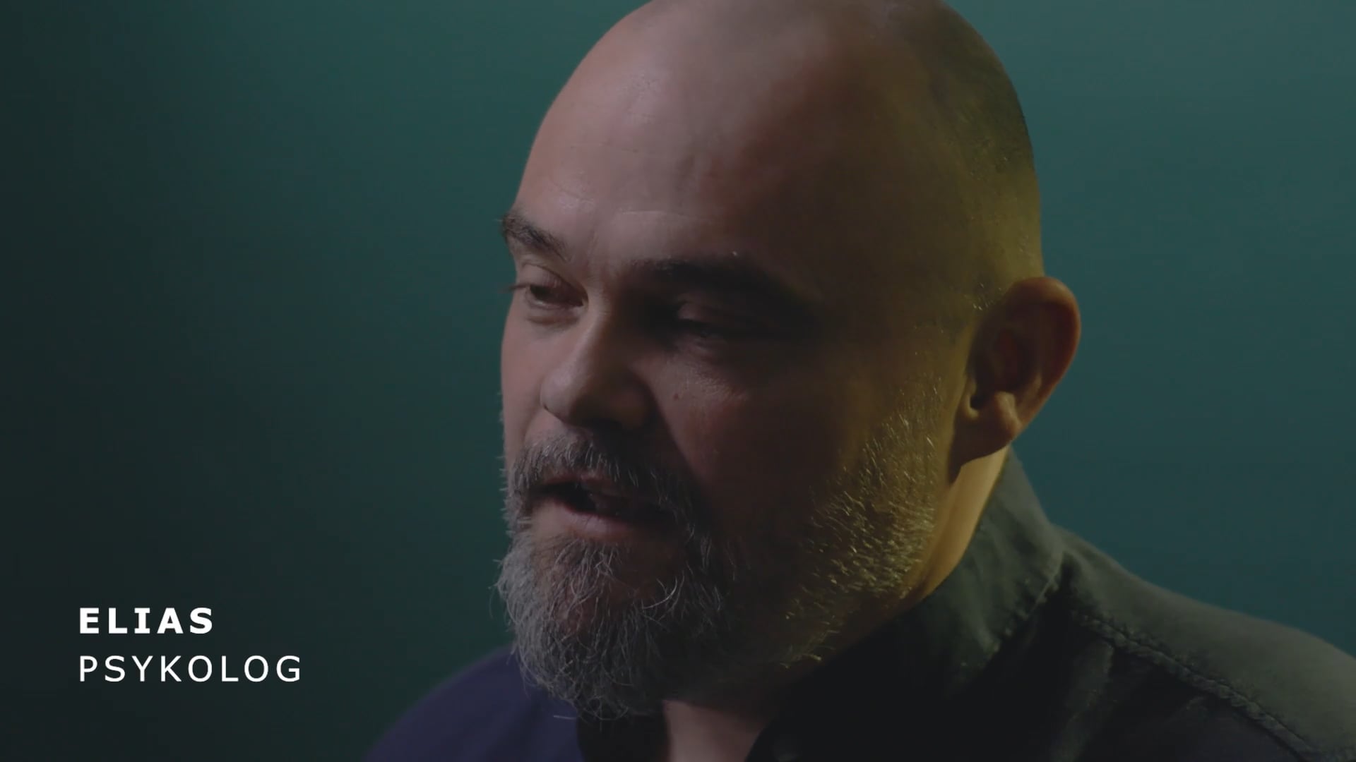 Psykologen Elias taler i profil mod mørk baggrund.