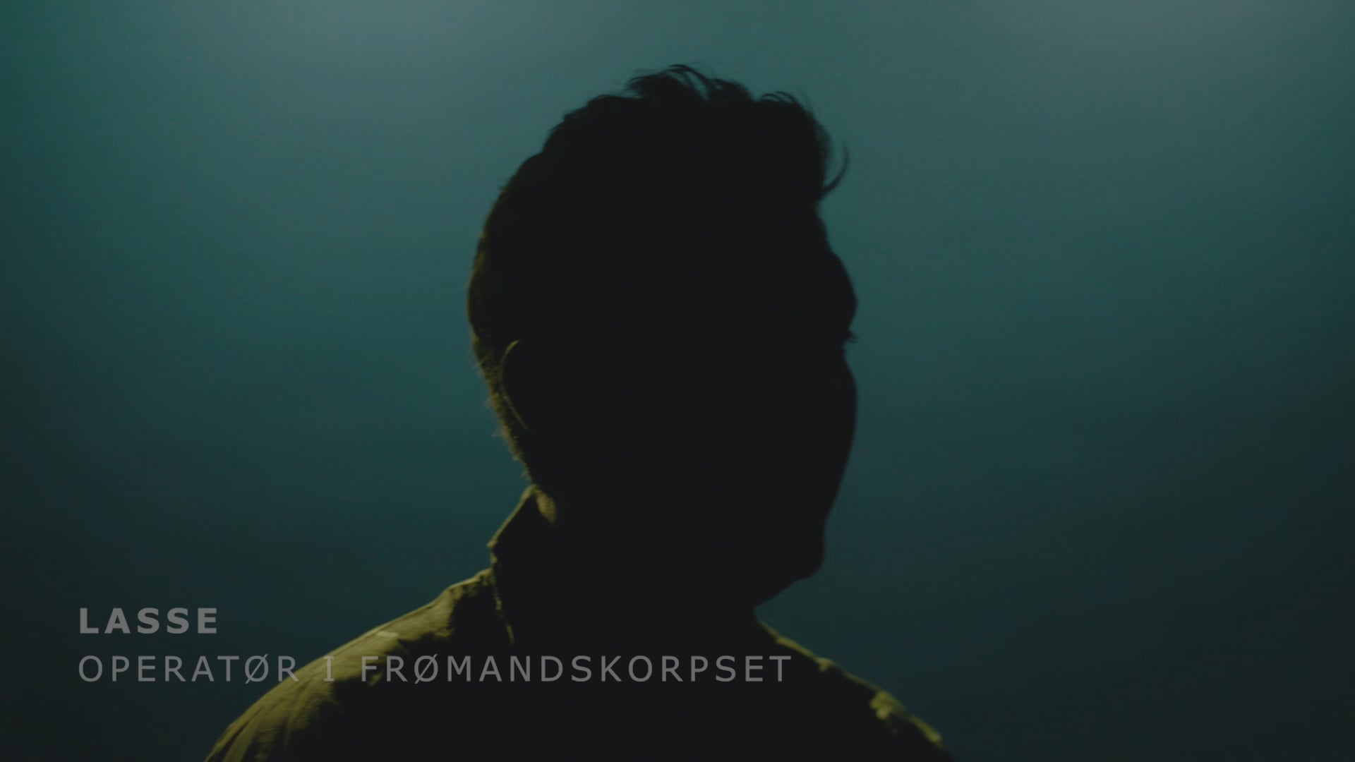 Silhuet af Lasse, operatør i Frømandskorpset, mod mørk baggrund