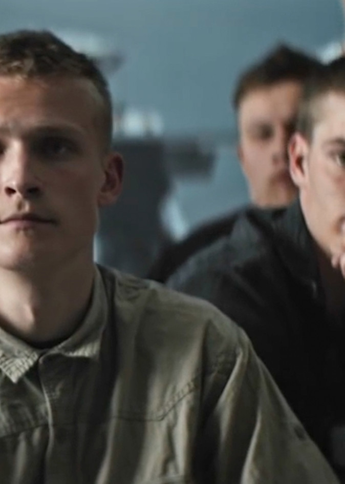 Unge mænd sidder i et undervisningslokale og lytter opmærksomt under en præsentation eller samtale.